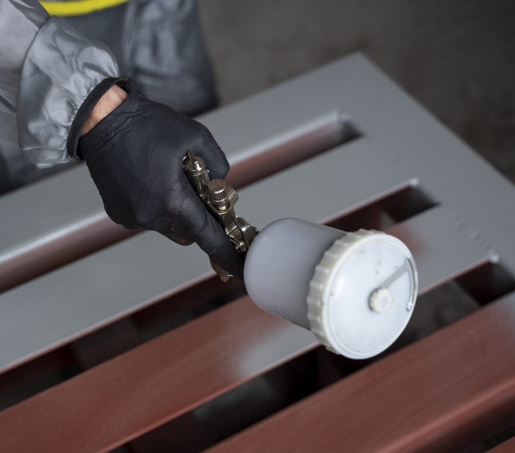 high-angle-worker-spraying-powder-paint-from-gun